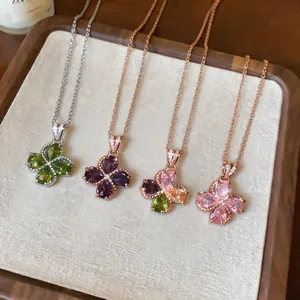 Detail view of four elegant zircon flower pendants in various colors on chains