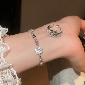 Nahaufnahme eines funkelnden Strass-Blumenarmbands und passenden silbernen Ringsets am Arm