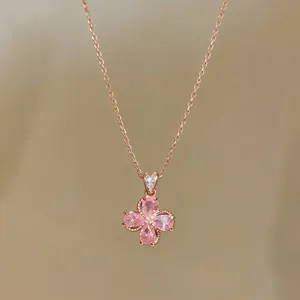Detailed view of rose gold flower pendant necklace featuring sparkling pink teardrop stones