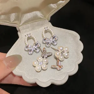 Close-up of elegant French style butterfly earrings with sparkling zircon and pearls
