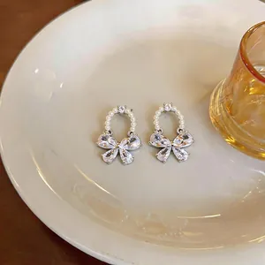Detailed macro view of elegant zircon butterfly stud earrings with delicate pearl beads