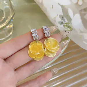 Detailed view of luxury geometric zirconia earrings with yellow layered shell discs