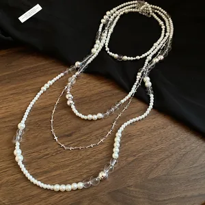 Elegant macro view of French vintage multi-layer pearl necklace with small cross charms.