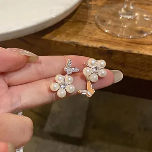 Close-up detail of exquisite French style asymmetric zircon butterfly pearl flower earrings
