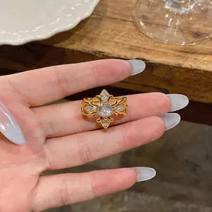 Detailed macro view of a French vintage gold ring with fleur-de-lis pattern and zircon stones