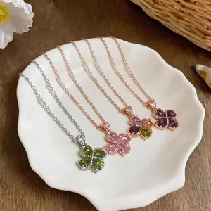 Close-up of four-leaf clover necklaces with vibrant zircon stones in a shell plate
