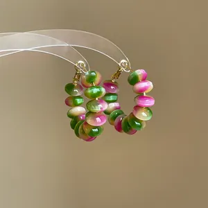 Detail view of vibrant gradient green and pink resin bead hoop earrings for summer