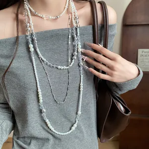 Detail view of French vintage pearl and cross necklace layering set on model.