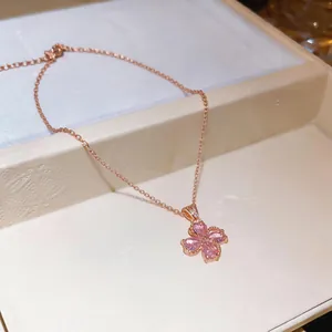 Close-up of a rose gold necklace with a pink zircon flower pendant on a jewelry box