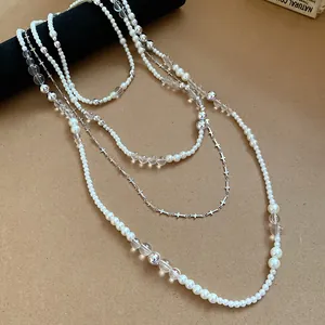 Detailed view of French vintage multi-layer pearl necklace set with silver cross charms