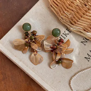 Boucles d'oreilles vintage style palais français avec pierres vertes et fleurs d'or.