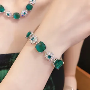 Nahaufnahme eines eleganten Armbands mit smaragdgrünen Zirkonia-Blütenanhängern