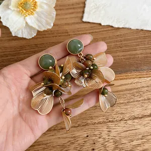 Gros plan sur des boucles d'oreilles fleurs dorées de style vintage français chic.