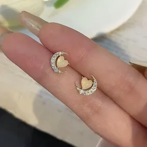 Delicate gold-tone moon stud earrings featuring a cat's eye heart and pavé crystals