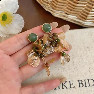 Vue détaillée de boucles d'oreilles fleurs vintage avec pétales dorés et perles