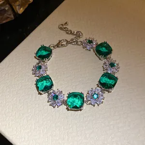 Detaillierte Makroansicht eines silbernen Armbands mit smaragdgrünen Zirkonia-Blüten