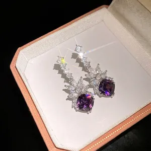 Elegant purple cushion-cut zircon drop earrings displayed in a luxury vintage jewelry box