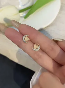 Close-up of crescent moon stud earrings with heart-shaped cat's eye stone