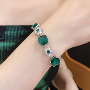 Detailaufnahme eines eleganten smaragdgrünen Zirkon-Blumenarmbands am Handgelenk