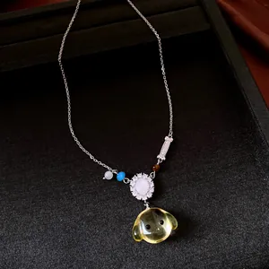 Detailweergave van modeketting met hanger van hars hondenkop en zirkoonbloemelement