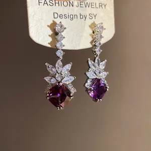 Close-up of elegant purple zircon rhombus earrings with sparkling marquise accents