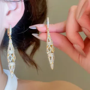 Detailed view of 18K gold-plated rhombic hollow earrings with sparkling zircon settings