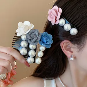 Close-up of French style elegant fabric flower and pearl hair comb worn by model
