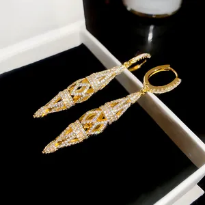 Detailed close-up of 18K gold plated zircon hollow rhombus drop earrings in jewelry box