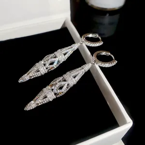 Close-up of sparkling cubic zirconia rhombus cutout hoop earrings in white jewelry box