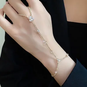Elegant gold-tone hand chain ring bracelet with sparkling rhinestone floral clusters