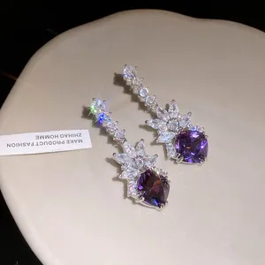 Close-up of elegant purple gemstone drop earrings with sparkling zircon accents.