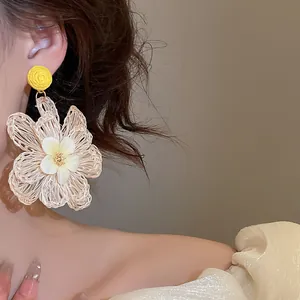 Detailed close-up of a bohemian raffia flower earring with delicate woven texture