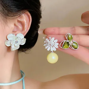 Detailed view of elegant enamel flower earrings with zircon and pearl accents for women