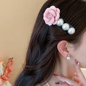 Detail showing a French style hair clip with a pink fabric rose and white pearls