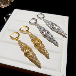 Detailed view of 18K gold plated and silver hollow rhombus earrings with pavé zirconia