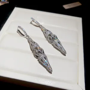 Close-up of elegant sparkling zircon hollow-out diamond drop earrings on white display