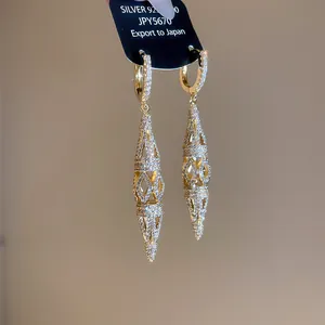 Close-up of 18K gold plated hollow diamond earrings with sparkling pavé zircons.