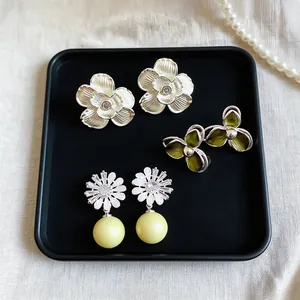 Elegant detail showing three styles of French vintage floral stud earrings with pearls