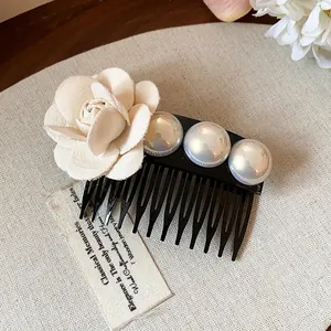 Close-up detail of a French style hair comb with fabric rose and iridescent pearls