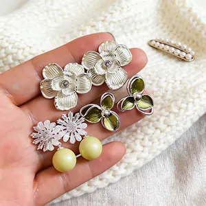 Detailed macro shot of assorted floral stud earrings featuring oil-drop petals and pearls