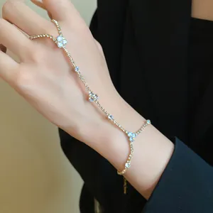 Detailed shot of an elegant gold rhinestone hand harness bracelet ring with clover accents