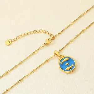 Vista detallada del collar de acero al titanio dorado con colgante Piscis de esmalte azul