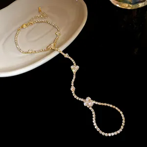 Close-up of elegant gold plated hand chain bracelet with sparkling crystal flowers