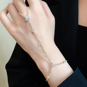 Close-up of minimalist gold hand harness with sparkling rhinestone flower motifs