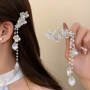Close-up of elegant flower hair clip with pearl tassels and rhinestones.