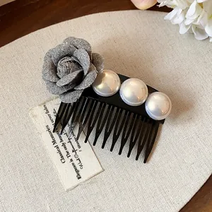 Close-up detail of an elegant French style hair comb with grey fabric rose and white pearls
