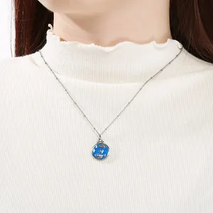 Primer plano de un colgante de Piscis en esmalte azul con cadena de acero inoxidable