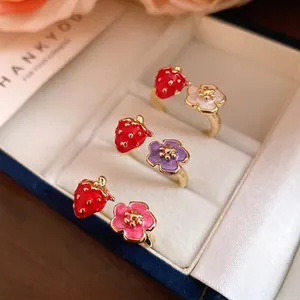 Set of three enamel strawberry and flower adjustable open rings in a jewelry box