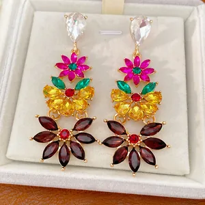 Detailed close-up of vintage multi-color floral rhinestone dangle earrings in a jewelry box