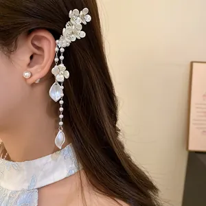 Elegant close-up of a white pearl flower tassel hair clip with shiny rhinestones